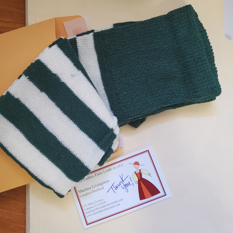 Striped socks being put into a mailing envelope.